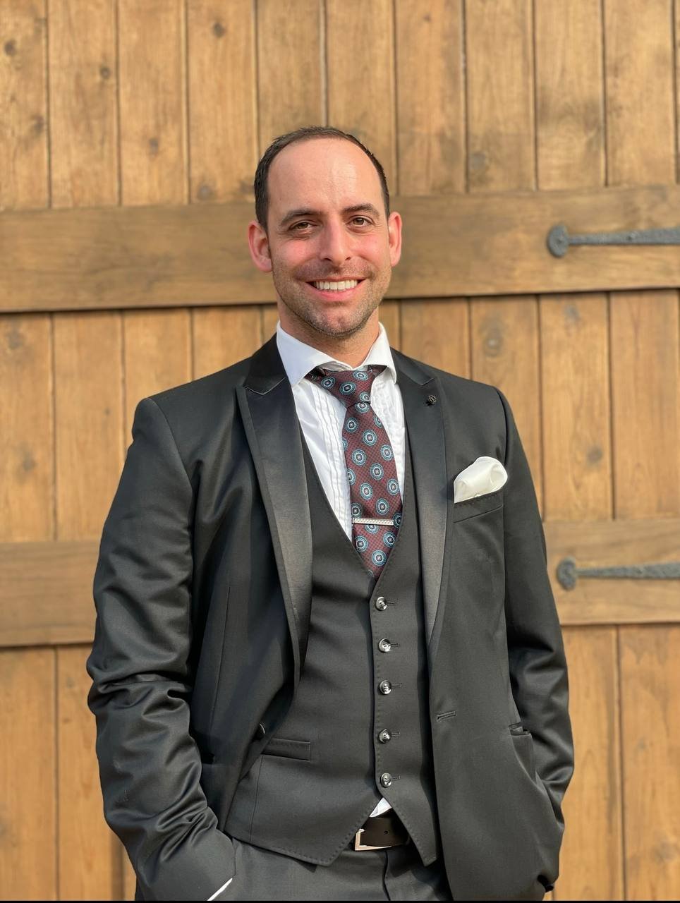Naz Magic in a suit, looking at the camera
