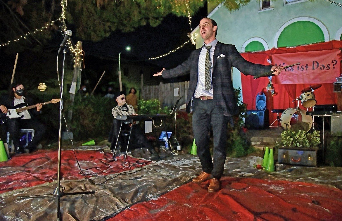Naz Magic performing on stage in a suit
