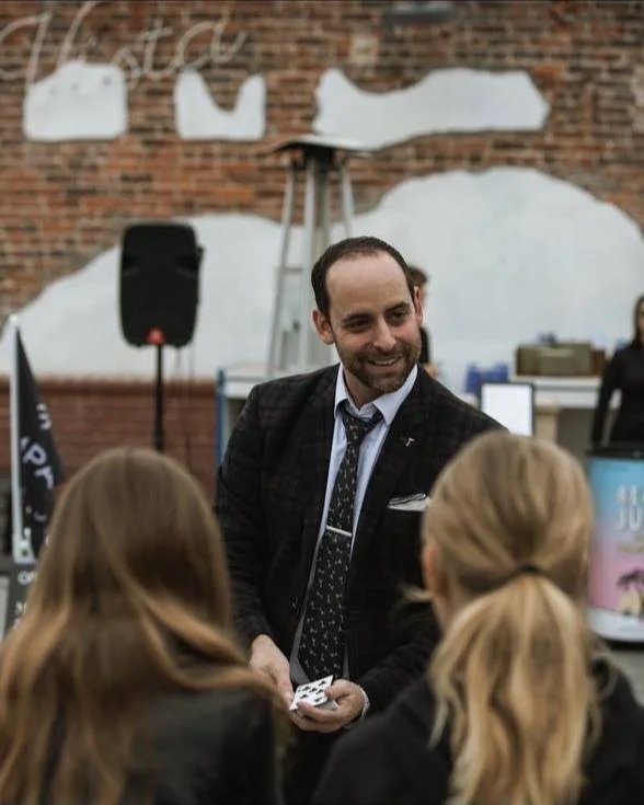 Naz Magic performing for guests in a suit