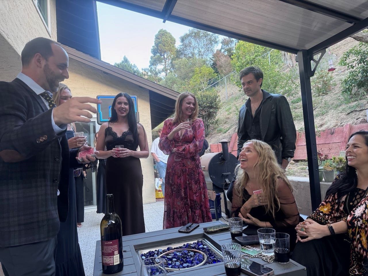 Naz Magic entertaining guests gathered around a patio table
